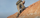 Angled View of Hunter Climbing Down Steep Rock Face Wearing Women's Attack Pants in Valo Camouflage