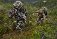 Hunters backpacking and trekking up a brushy mountain trail