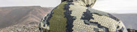Back of hunter on a mountain top wearing the KUIU Kutana Storm Shell Jacket in Verde Camouflage