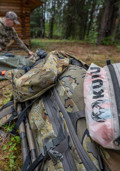 Close up image of KUIU pack being organized by kneeling hunter in unfocused background of image