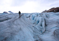 Hunter walks on a icy mountain top, surrounded by icy crevices