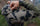 Profile view of a man wearing the Peloton 240 Full Zip Hoodie in verde camouflage