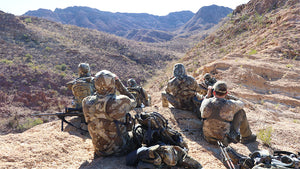 Six hunters in Valo Camouflage glassing on a rocky mountaintop