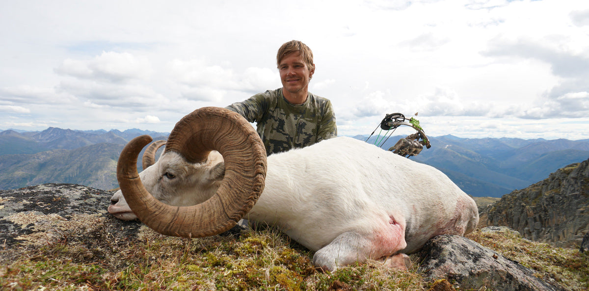 Allen Bolen in Verde camouflage with his record book stone sheep harvested with his bow in the Yukon