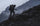 Silhouette side profile of hunter carrying out dall sheep while climbing uphill through rock shale