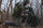 Turkey hunter kneeling in the woods holding the KUIU Rival Turkey Vest in Verde Camouflage