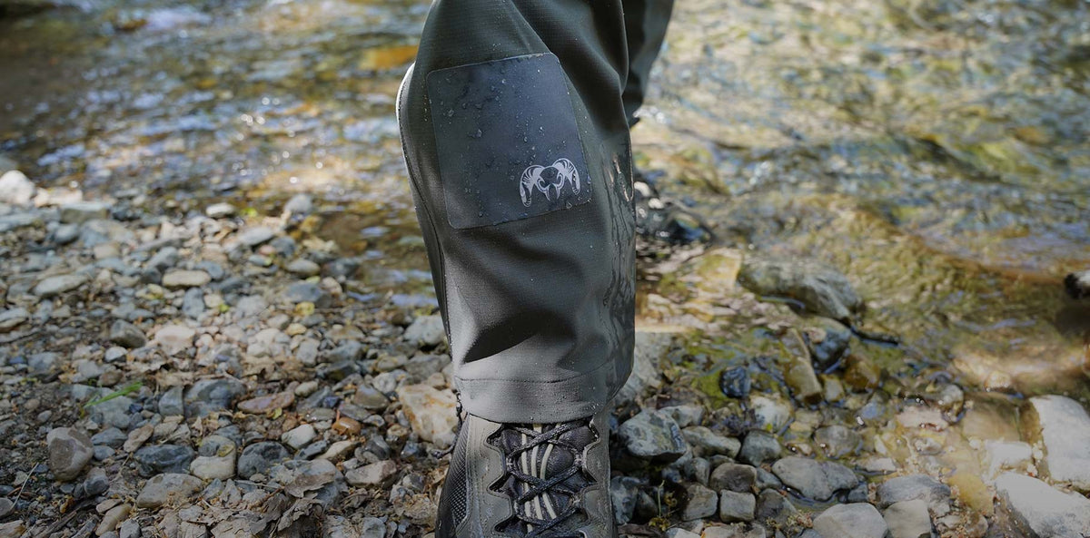 Close up image of gunmetal grey NOSO repair patch applied to Kutana Storm Shell Rain Pant