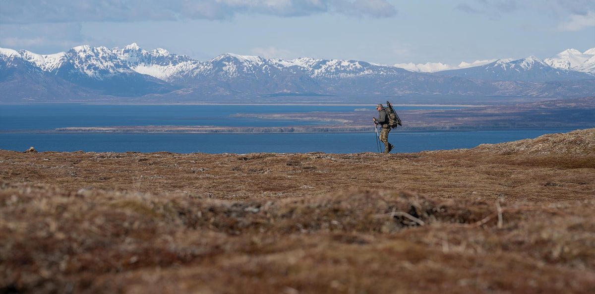 A hunter backpacking across the tundra.