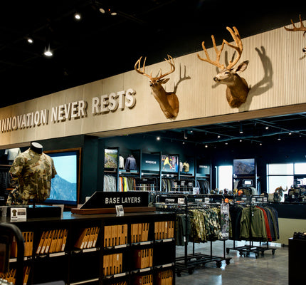Denver Store interior with mounted deer heads and 'Innovation Never Rests' sign.
