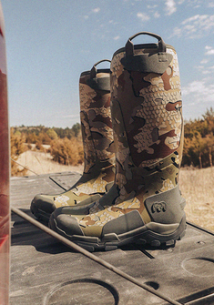 Side profile of KUIU HD Mud Boot in Valo Camouflage,standing upright on a truck’s tailgate 