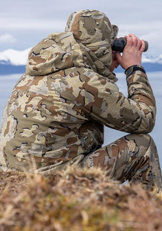 Hunter sitting and glassing from a viewpoint, wearing StrongFleece 275 Full Zip Hoodie in Valo Camouflage 