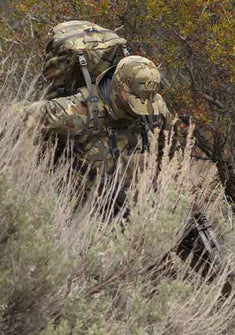 Front, Angled View of Hunter Climbing Down Steep Sage Slope Wearing Valo Camouflage