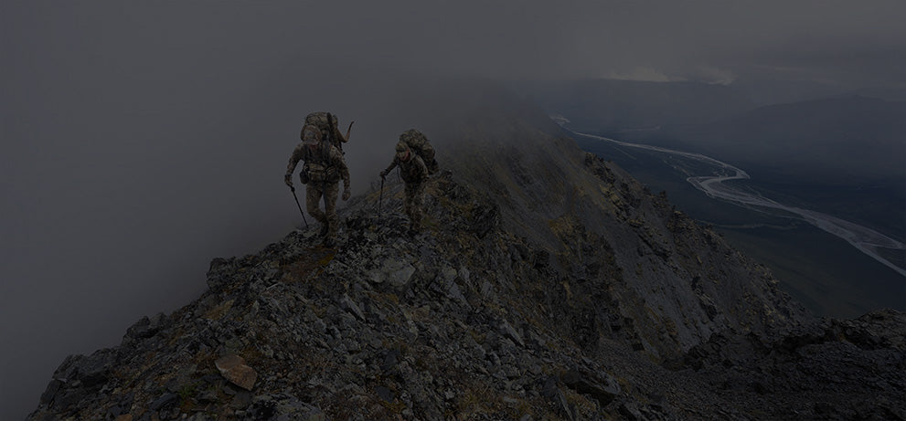 Two hunterers hiking on a rocky ridge wearing Vias Camouflage.